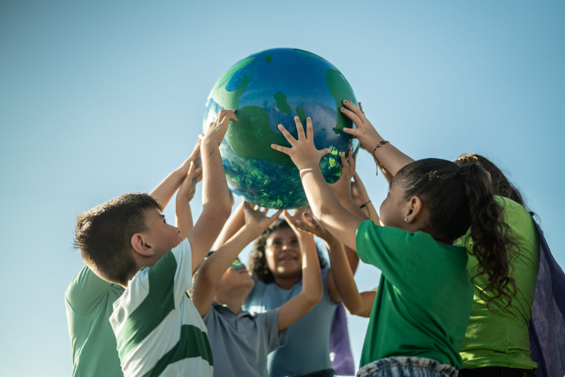 Children holding a planet outdoors