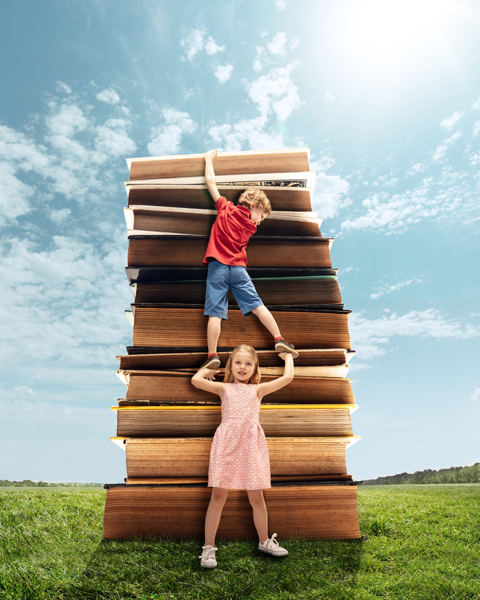 Little girl and boy climbing on the tower made of big books. Childhood dreams, reading and education concept. Wondering world. abstract collage